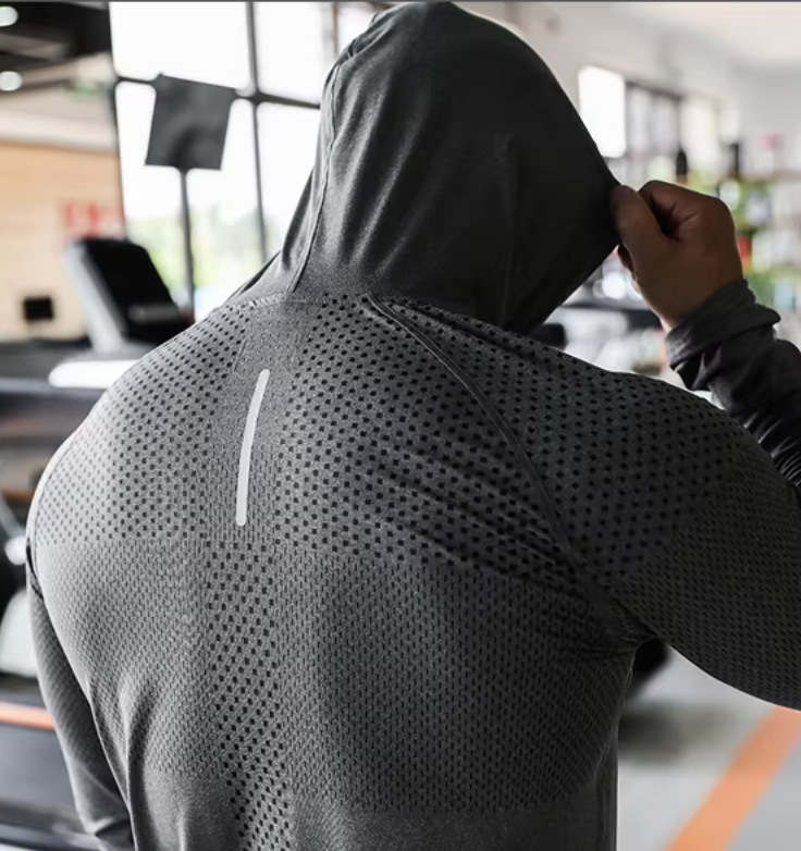 Man showing the athletic hooded sweatshirt from behind displaying his muscle definition with the hood on